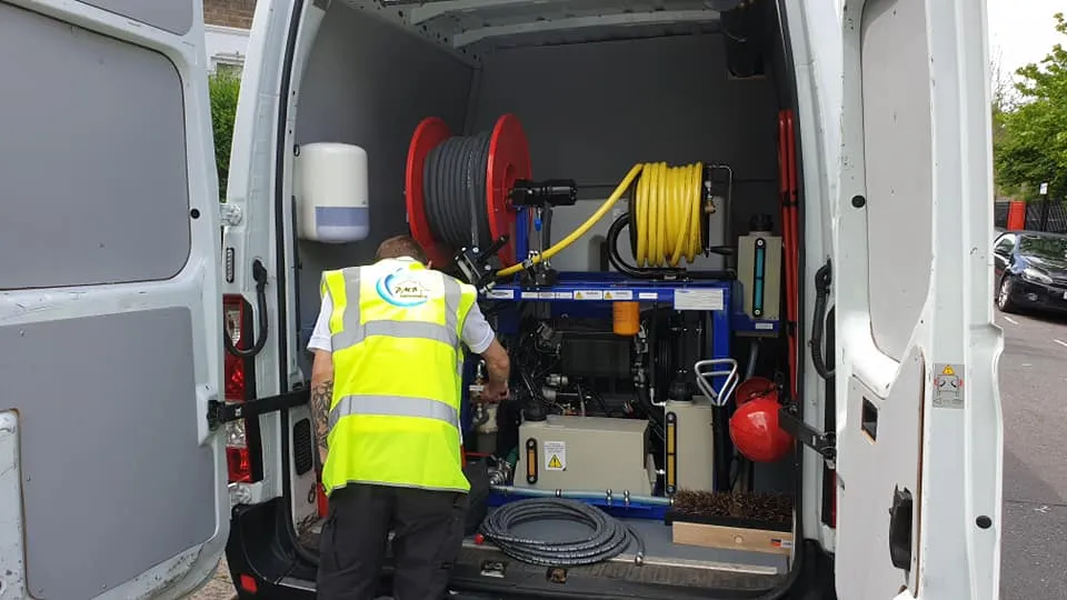 man in high vis vest in the back of a van